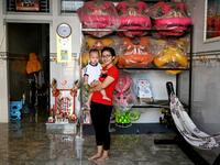 This photograph taken on January 20, 2021 shows Le Yen Quyen posing with her one-year-old daughter before leaving for practice at the Tu Anh Duong lion and dragon dance school in Can Tho city in southern Vietnam's Mekong Delta. Manan VATSYAYANA / AFP