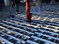 A Myanmar activist holds a portrait of Myanmar's de facto leader Aung San Suu Kyi as portraits of the country's military general Min Aung Hlaing are seen on the floor during a a protest outside the United Nations University building in Tokyo on February 1, 2021 following a military coup in the country by a general after arresting civilian leader Aung San Suu Kyi and other senior officials. Philip FONG / AFP