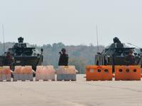Soldiers stand guard on a blockaded road to Myanmar's parliament in Naypyidaw on February 1, 2021, after the military detained the country's de facto leader Aung San Suu Kyi and the country's president in a coup. STR / AFP