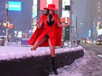 A woman climbs over snow covered wall in Time Square during a winter storm on February 1, 2021 in New York City. A powerful winter storm is set to dump feet of snow along a stretch of the US east coast including New York City on February 1, 2021, after blanketing the nation's capital. ANGELA WEISS / AFP
