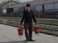In this picture taken on February 9, 2021, street actor Usman Khan, dressed up as silent film star Charlie Chaplin, performs at a train station in the Pakistan's northwestern city of Peshawar. Wearing a bowler hat and familiar toothbrush moustache, Pakistan's Usman Khan darts through traffic swinging a cane, teasing motorists and shopkeepers for laughs and a few rupees with a Charlie Chaplin impersonation that has become a viral sensation.  Abdul MAJEED / AFP