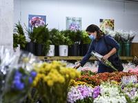 A woman buys flowers from Miami’s oldest florist, Berkeley Florist Supply, on February 13, 2021. The flower market was started in 1947. The President of Berkeley Florist, Morey Moss, says he has been experiencing overwhelming sales in 2021 after his business was badly hit by the pandemic. CHANDAN KHANNA / AFP