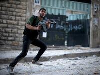 Syrian rebel aims his weapon during clashes with government forces 