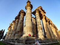 A costumed actress sits by a column during the filming of a television production at the Temple of Zeus in the ruins of Libya