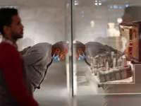 People look at displayed artifacts at Egypt's new National Museum of Egyptian Civilisation (NMEC)