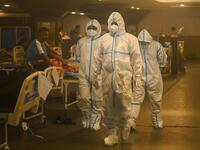 Health workers wearing personal protective equipment (PPE kit) attends to Covid-19 coronavirus positive patients inside a banquet hall 