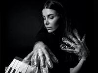 A musician in foil gloves is playing an instrument
