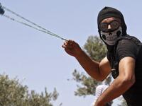A Palestinian protestor throws a rocks at Israeli security forces during clashes in the village of Beita, south of Nablus
