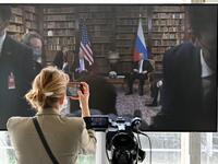 A journalist takes a picture of the screen displayed in the press room showing US President Joe Biden and Russian President Vladimir Putin during the US-Russia summit at the Villa La Grange, in Geneva 