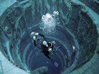 A diver experiences Deep Dive Dubai, the deepest swimming pool in the world reaching 60m, in the United Arab Emirates, on July 10, 2021. The city of superlatives, with the world's tallest tower among its many records, Dubai now has the deepest swimming pool on the planet complete with a "sunken city" for divers to explore. GIUSEPPE CACACE / AFP