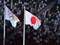 An overview shows the Olympic (L) and Japan's national flag fluttering with empty stands seen in the background during the opening ceremony of the Tokyo 2020 Olympic Games, at the Olympic Stadium, in Tokyo