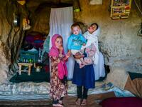 In this picture taken on October 3, 2021, Hazara ethnic children stand in their cave on a cliff pockmarked by caves where people still live as they did centuries ago in Bamiyan. 