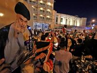 Supporters of Iraqi Shiite cleric Muqtada al-Sadr ride in vehicles while celebrating in the central shrine city of Najaf after the closure of polls during the early parliamentary elections on October 10, 2021. (Photo by Ali NAJAFI / AFP)