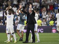 Real Madrid's Italian coach Carlo Ancelotti (C), Real Madrid's Brazilian forward Vinicius Junior (L) and teammates acknowledge the crowd at the end of the Spanish league football match between Real Madrid CF and Real Betis at the Santiago Bernabeu stadium in Madrid on May 20, 2022. (Photo by Pierre-Philippe MARCOU / AFP)