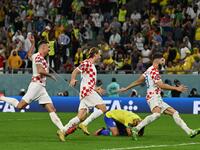 Croatia players celebrate past Brazil's defender #04 Marquinhos (C) after they won on penalty shoot-out the Qatar 2022 World Cup quarter-final football match between Croatia and Brazil at Education City Stadium in Al-Rayyan, west of Doha, on December 9, 2022. (Photo by NELSON ALMEIDA / AFP)