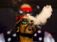 Snoop Dogg blows smoke as he performs on stage at the Accor Arena of Bercy, in Paris. (Anna Kurth/ AFP)