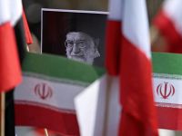 A protestor holds a placard with an image of the late Iranian Supreme Leader Ayatollah Ali Khamenei surrounded by Iranian flags outside the US consulate during a protest against the conflict in the Middle East in Mexico City on March 7, 2026. (Photo by Carl de Souza / AFP)