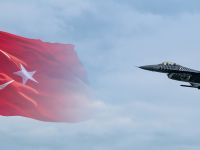 طائرة مقاتلة تركية من طراز سولوتورك F-16 تحلق أمام خلفية علم تركيا.