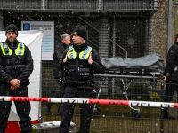 Police stand behind a cordon as the body of one of the victims is taken away at site where several people were killed in a church in a shooting the night before in Hamburg, northern Germany on March 10, 2023. (TOBIAS SCHWARZ / AFP)