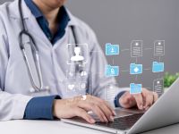 طبيب يستخدم حاسوباً محمولاً مع ظهور رموز رقمية تمثل السجلات الطبية 