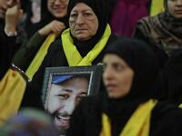 A Lebanese woman carries a portrait of her dead son as she attends a gathering for a televised speech held by the Shiite party in the capital Beirut, commemorating the party's killed leaders, on Feb. 16, 2018. 
(JOSEPH EID / AFP)