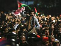 Jordanian protesters shout slogans and raise a national flag during a demonstration outside the Prime Minister's office in the capital Amman late on June 2, 2018. 
Khalil MAZRAAWI / AFP