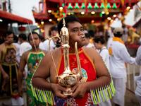 A devotee of the Loem Hu Thai Su shrine has a metal jug pierced through his cheek during the annual Vegetarian Festival in Phuket on October 12, 2018. Jewel SAMAD/AFP