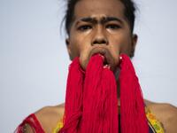 A devotee of the Loem Hu Thai Su shrine parades with coloured yarn through large piercings in his face during the annual Vegetarian Festival in Phuket on October 12, 2018. Jewel SAMAD/AFP