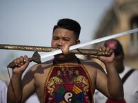 A devotee of the Loem Hu Thai Su shrine parades with a sword and a cover pierced through his cheek during the annual Vegetarian Festival in Phuket on October 12, 2018. Jewel SAMAD/AFP