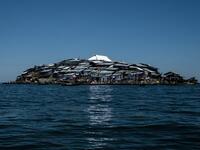 A picture taken on October 5, 2018, shows a newly-built tin roof shining on top of Migingo island which is densely populated by residents fishing mainly for Nile perch in Lake Victoria on the border of Uganda and Kenya. 
Yasuyoshi CHIBA / AFP