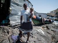 A woman holds her baby on Migingo island on October 5, 2018 which is densely populated by residents fishing mainly for Nile perch in Lake Victoria on the border of Uganda and Kenya. 
Yasuyoshi CHIBA / AFP