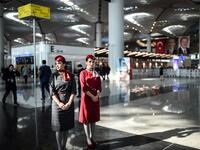 Air hostesses walk during the opening ceremony of Istanbul's third airport, the Istanbul New Airport, in the Arnavutkoy district on the European side of Istanbul on October 29, 2018. 
BULENT KILIC / AFP
