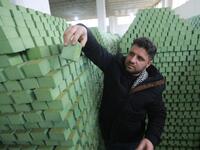 Syrian businessman Ali Shami arranges olive soap bars in a factory on the outskirts of Aleppo 
LOUAI BESHARA / AFP