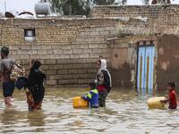 An Iranian family walks through a flooded street in a village around the city of Ahvaz, in Iran's Khuzestan province
Mehdi Pedramkhoo / TASNIM NEWS / AFP