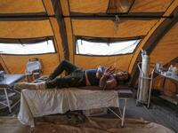 An Iranian quake victim lies on an operating bed after receiving treatment at a field hospital.

(ATTA KENARE / AFP) 