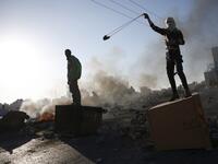 A Palestinian protestor uses a slingshot during clashes with Israeli forces near an Israeli checkpoint in the West Bank city of Ramallah. (ABBAS MOMANI / AFP)