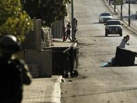 A member of the Israeli forces (L) holds a position as a Palestinian protestor throws stones during clashes following a demonstration by the Popular Front for the Liberation of Palestine (PFLP) in Bethlehem in the Israeli occupied West Bank. 
(Musa AL SHAER / AFP)