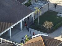People are brought out of the Marjory Stoneman Douglas High School after a shooting at the school that reportedly killed and injured multiple people on Feb. 14, 2018 in Parkland, Florida. Numerous law enforcement officials continue to investigate the scene. 
(Joe Raedle/Getty Images/AFP)