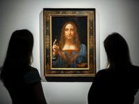 Christie's employees pose in front of a painting entitled Salvator Mundi by Italian polymath Leonardo da Vinci at a photocall at Christie's auction house in central London on October 22, 2017 ahead of its sale at Christie's New York on November 15, 2017. (AFP/Tolga Akmen)