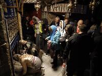 A group of tourists and pilgrims visit the Grotto, believed to be the exact spot where Jesus Christ was born, as others pray at the Church of the Nativity in the West Bank city of Bethlehem. Thomas Coex/AFP
