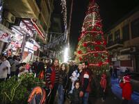 Syrians pose for a picture as they gather around a Christmas tree in the capital Damascus' central neighbourhood of Qassaa on December 21, 2018. 
LOUAI BESHARA / AFP