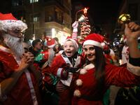 Syrian people dressed as Santa Claus walk in the capital Damascus' central neighbourhood of Qassaa to celebrate Christmas early on December 22, 2018. 
LOUAI BESHARA / AFP