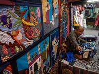 An Egyptian craftsman gestures as he sits while working on a tapestry in his shop in Khayamiya Street, or the Street of Tent-makers, in the old city of the Egyptian capital Cairo
Mohamed el-Shahed / AFP