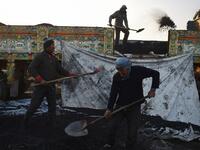 In this picture taken on January 8, 2019, Afghan labourers work at a coal yard amid heavy smog conditions in the outskirts of Kabul. 
WAKIL KOHSAR / AFP