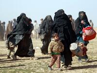 People who fled battles between Syrian Democratic Forces (SDF) and ISIS fighters in the Syrian village of Baghouz, arrive after crossing a desert in the back of a truck to a region controlled by the SFD in the countryside of the Deir Ezzor province. Delil SOULEIMAN / AFP