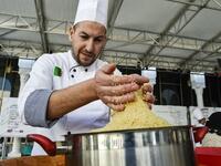 An Algerian chef prepares couscous during the 2nd edition of the International Couscous Festival at the Moufdi Zakaria Palace of Culture in  Algeria
RYAD KRAMDI / AFP