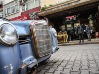 People stay outside an auction house in Istanbul's Balat district.
OZAN KOSE / AFP