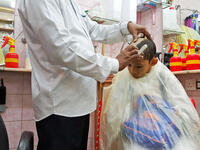 A young muslim boy getting his hair shaved as a rule to complete his rites of umrah and he can be free of his ihram and ihram's limitation (Shutterstock/File Photo)