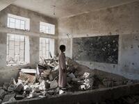 A pupil stands in the ruins of his former classroom, destroyed in June 2015 (Twitter)