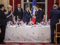 French President Emmanuel Macron (C-R), his wife Brigitte Macron (L), South Korean President Moon Jae-in (C-L) and his wife Kim Jung-sook (R) toast during a state dinner at the Elysee Presidential palace in Paris, on October 15, 2018. (Christophe Petit-Tesson / POOL / AFP)
